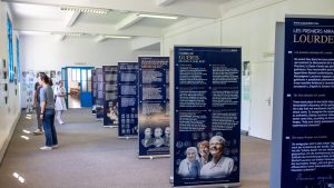 Interior do Museu dos Milagres em Lourdes, mostrando exposições sobre curas reconhecidas pela Igreja